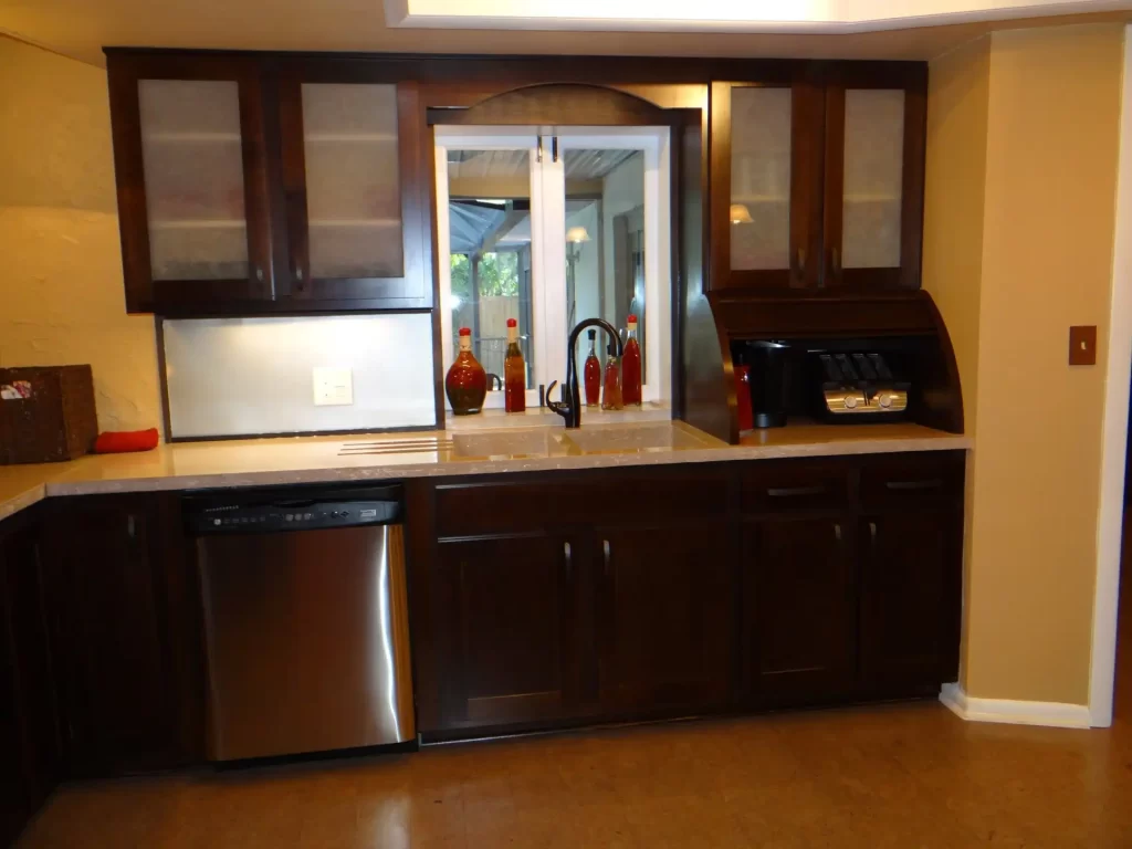 Newly installed kitchen faucet and cabinets within a custom bar renovation.